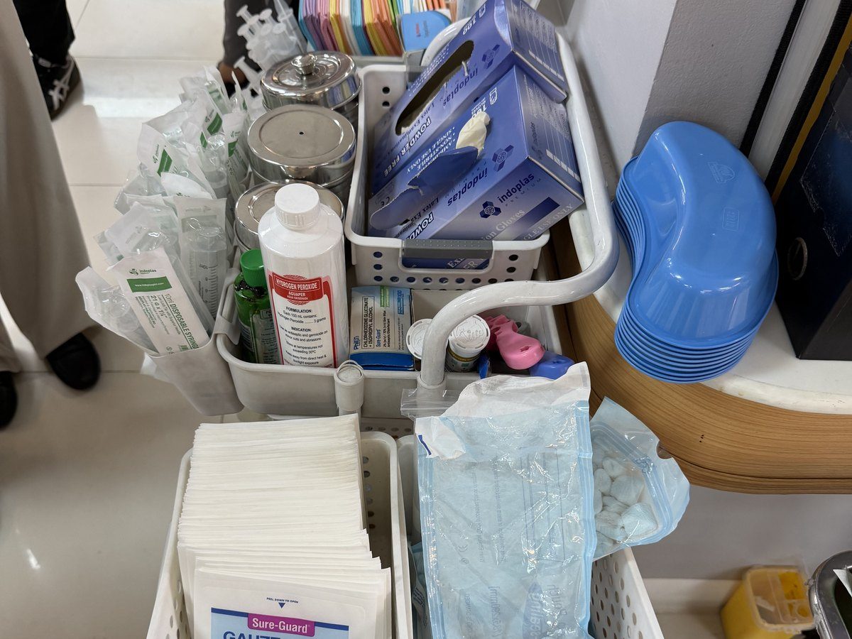 A supply cart: gauze, saline, trays and dressings.